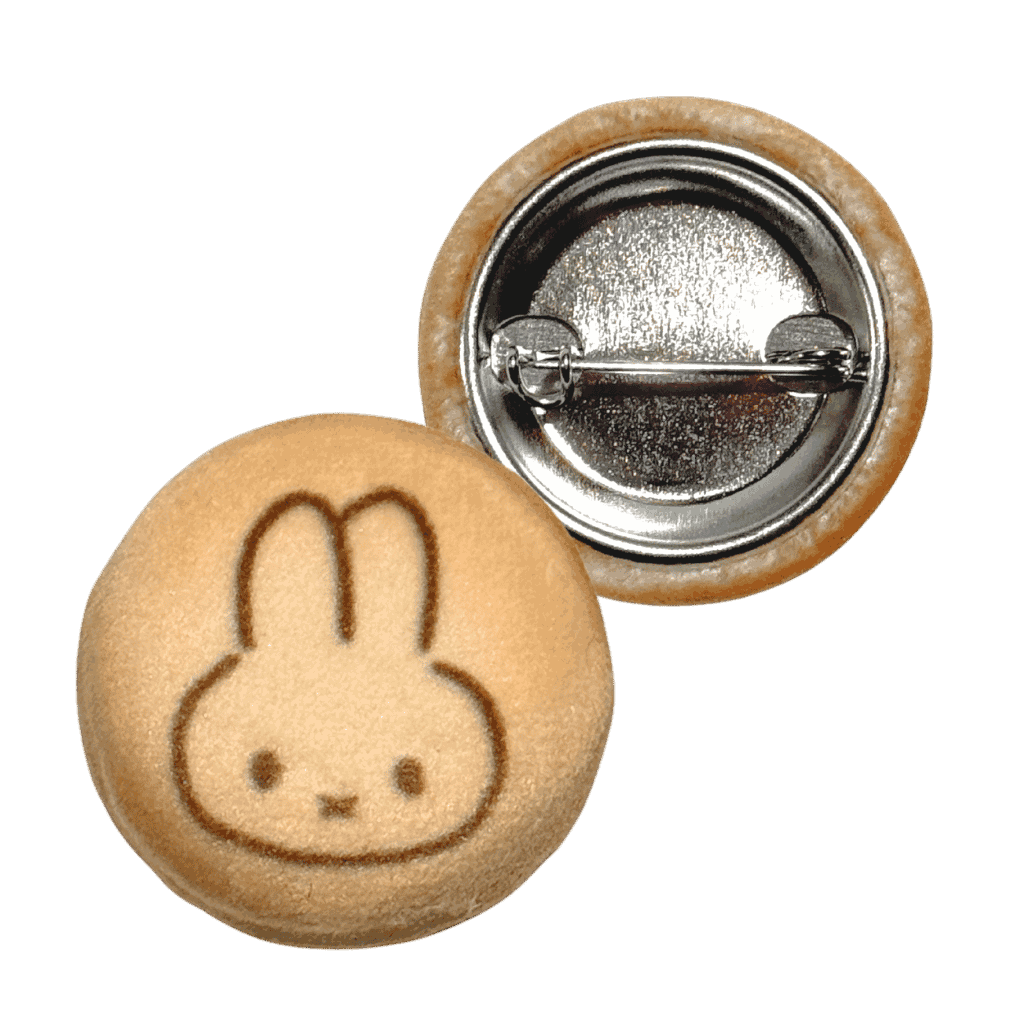 Plush button badge with a cartoon rabbit face design